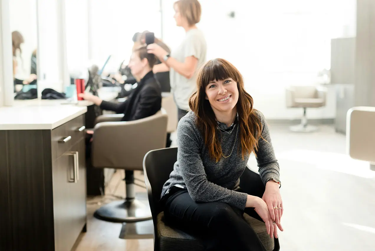 Person sitzt auf einem Stuhl in einem Friseursalon