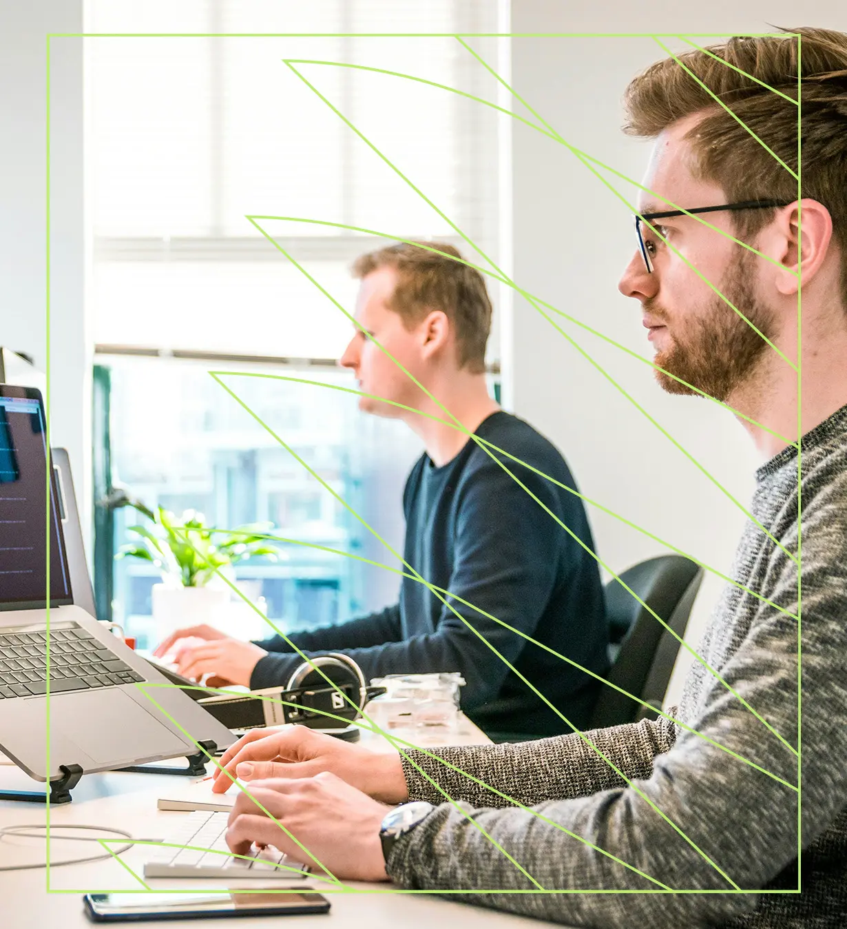 Zwei Personen arbeiten am Laptop im Büro